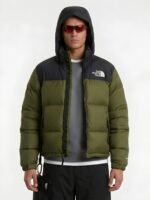 Front view of a man wearing an olive green puffer jacket with the hood up.