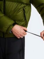 Close-up details of the adjustable hem cinch-cord on an olive green puffer jacket.