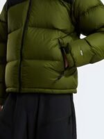 Side profile close-up of the zippered pocket and 700-fill embroidery on a green puffer coat.