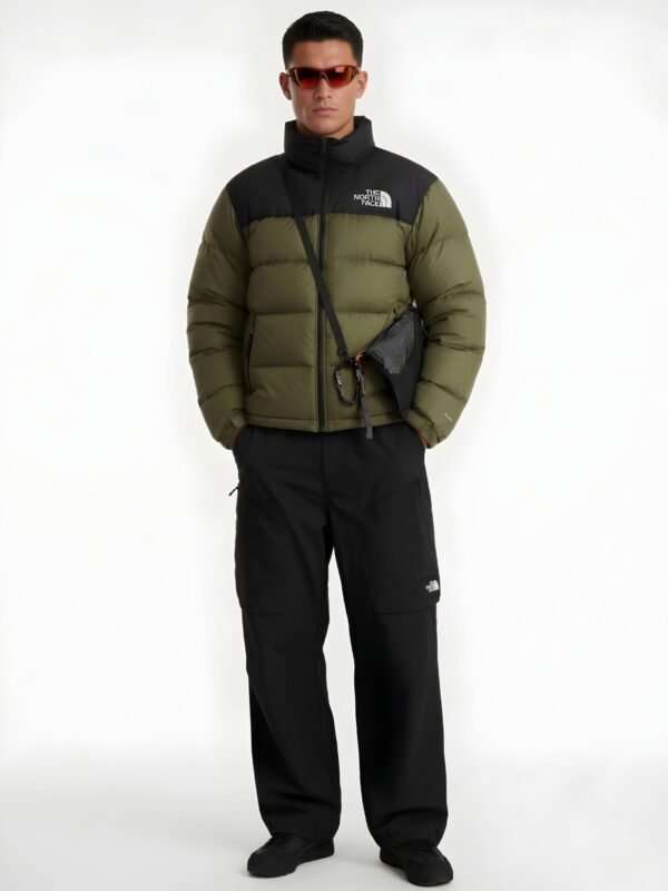 Full-body studio shot of a model wearing an olive green puffer jacket with black cargo pants.