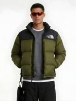 Front view studio mockup of a model in a men's olive green puffer jacket with collar up.