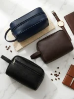 Navy blue, brown, and black leather travel dopp kits flatlay
