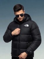 Close up of model adjusting zipper on black puffer jacket