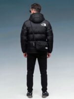 Model wearing black puffer jacket, side profile