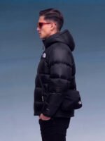 Model from the back wearing black puffer jacket and black crossbody bag