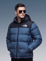 Model wearing blue puffer jacket from the back with black crossbody bag