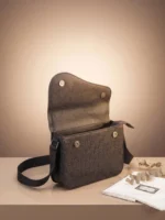 Open flap of a designer-inspired messenger bag showing dual magnetic snaps and a zipped interior.